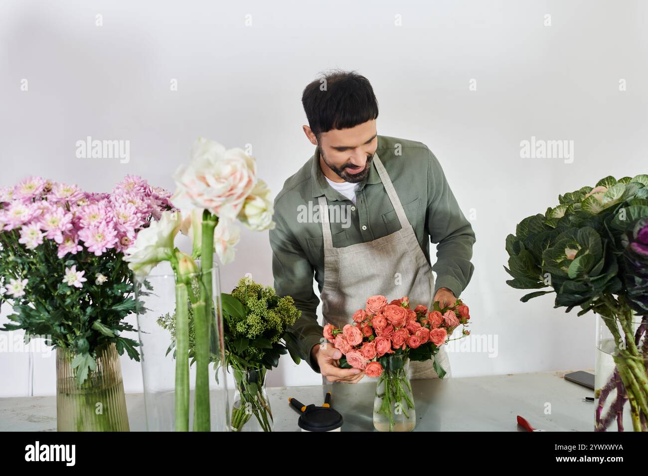 Un fiorista esperto crea uno splendido bouquet tra vegetazione lussureggiante e fiori, dando prova di creatività. Foto Stock