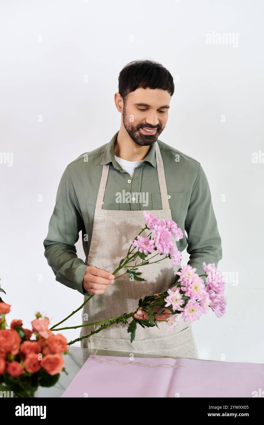 Un fiorista esperto crea splendidi mazzi circondati da fiori freschi. Foto Stock