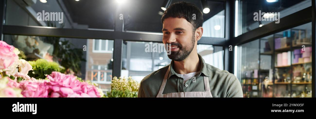 Un fiorista esperto sorride mentre organizza una splendida mostra di fiori in fiore nel suo negozio, banner Foto Stock