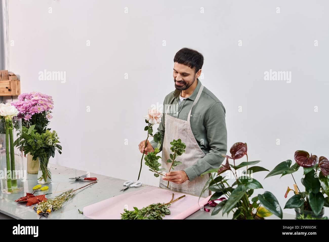 Un fiorista esperto prepara splendidi fiori con cura nel suo affascinante negozio. Foto Stock