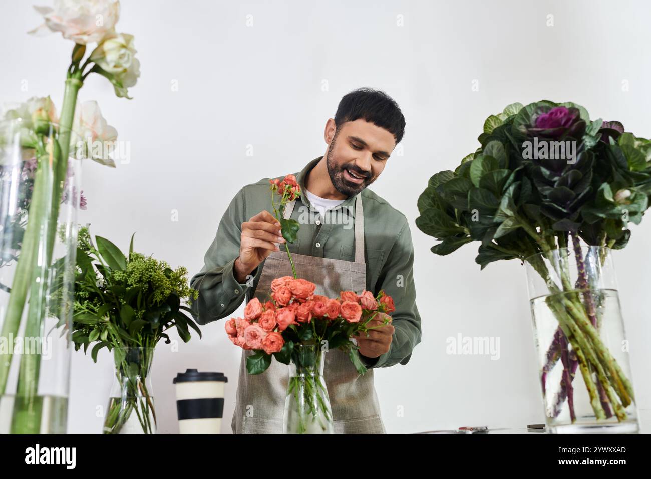 Un fioraio di talento organizza sapientemente splendide rose con un sorriso gioioso nel suo negozio. Foto Stock