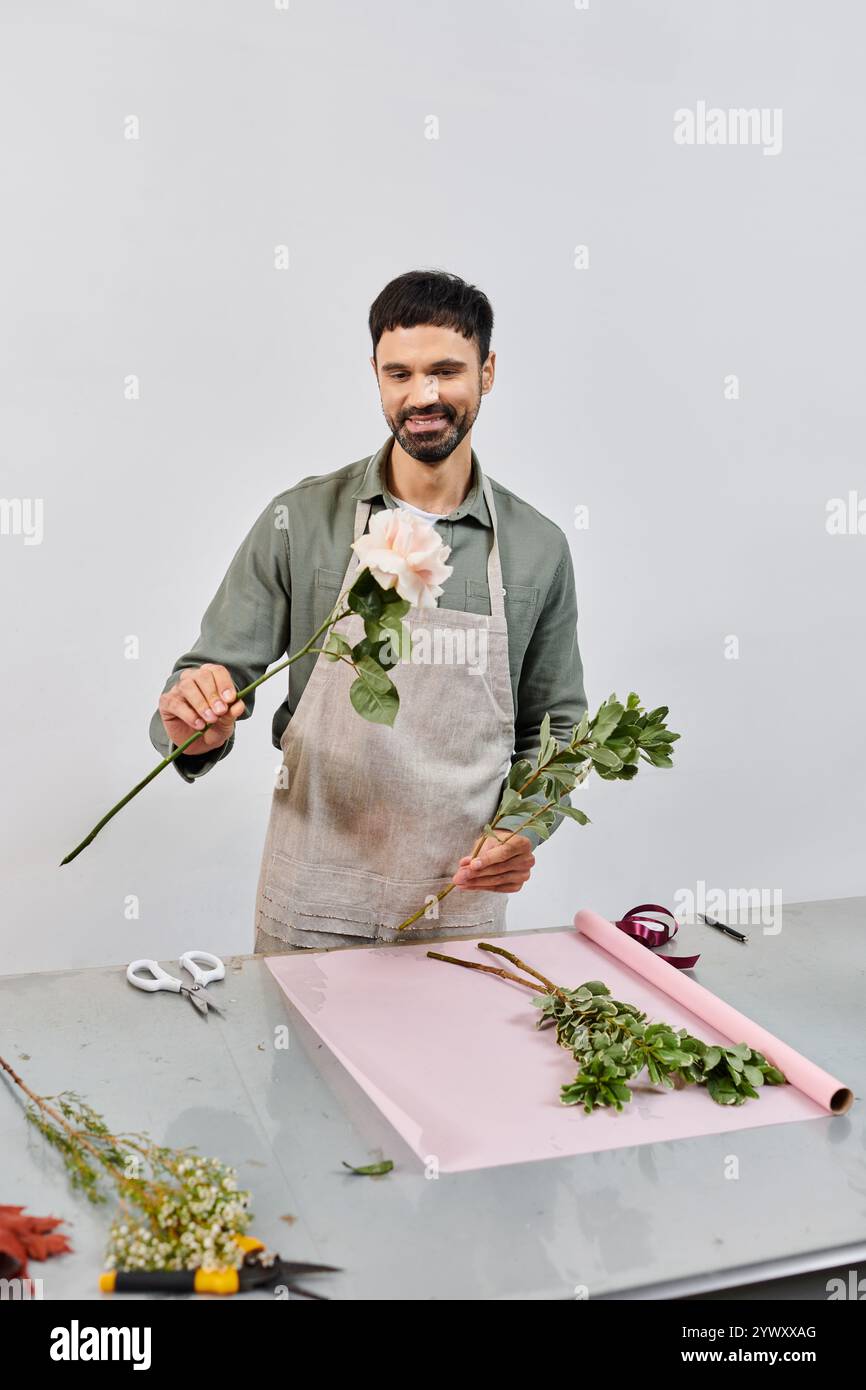 Un fiorista esperto lavora diligentemente, realizzando composizioni floreali con fiori freschi nel suo negozio. Foto Stock
