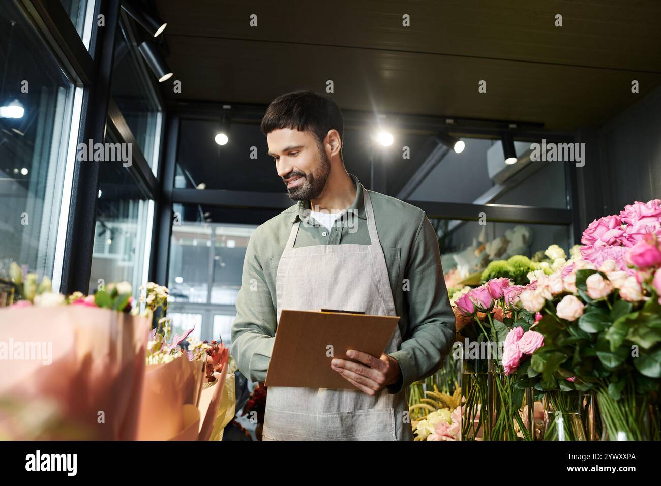 L'esperto floreale seleziona fiori squisiti mentre mostra la sua passione per le piante nel negozio. Foto Stock