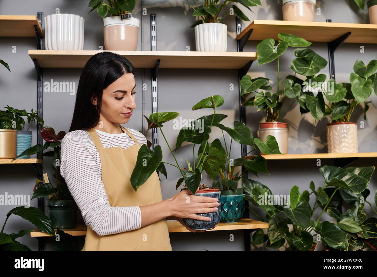 Fiorista che organizza con cura una lussureggiante vegetazione mentre è immerso nelle attività quotidiane di lavoro. Foto Stock