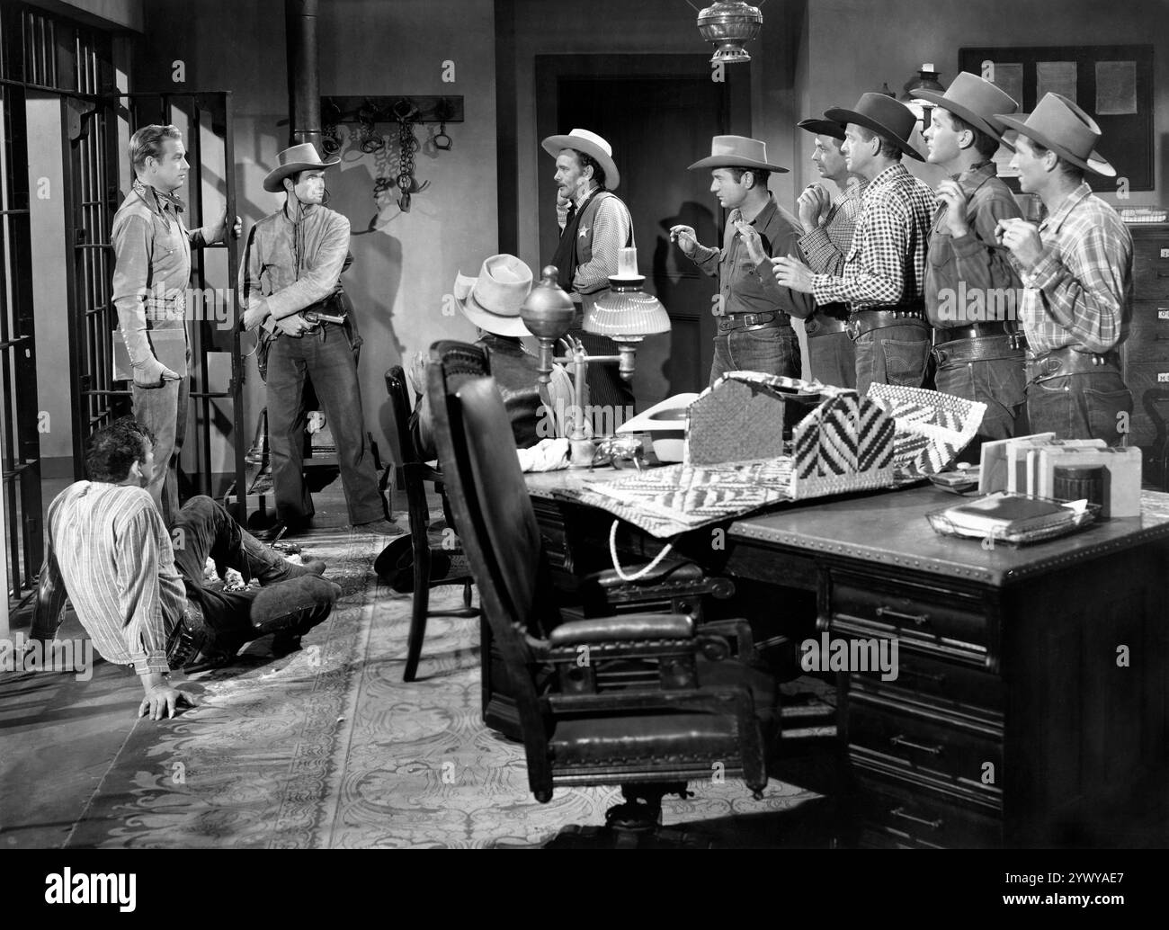 Rex Allen (in piedi a sinistra), Michael Hall (in piedi alla seconda a sinistra), Stan Jones (sceriffo), sul set del film western, 'The Last Musketeer', Republic Pictures, 1952 Foto Stock