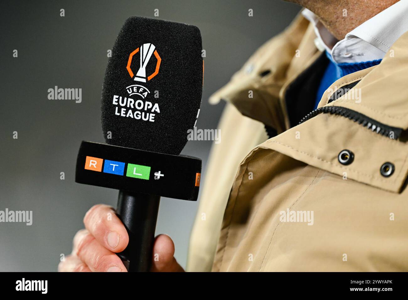 Sinsheim, Germania. 12 dicembre 2024. Calcio: Europa League, TSG 1899 Hoffenheim - FCSB Bucarest, turno preliminare, partita 6, PreZero Arena. Un presentatore ha un microfono con la scritta "UEFA Europa League - RTL" sullo schermo pop. Credito: Uwe Anspach/dpa/Alamy Live News Foto Stock