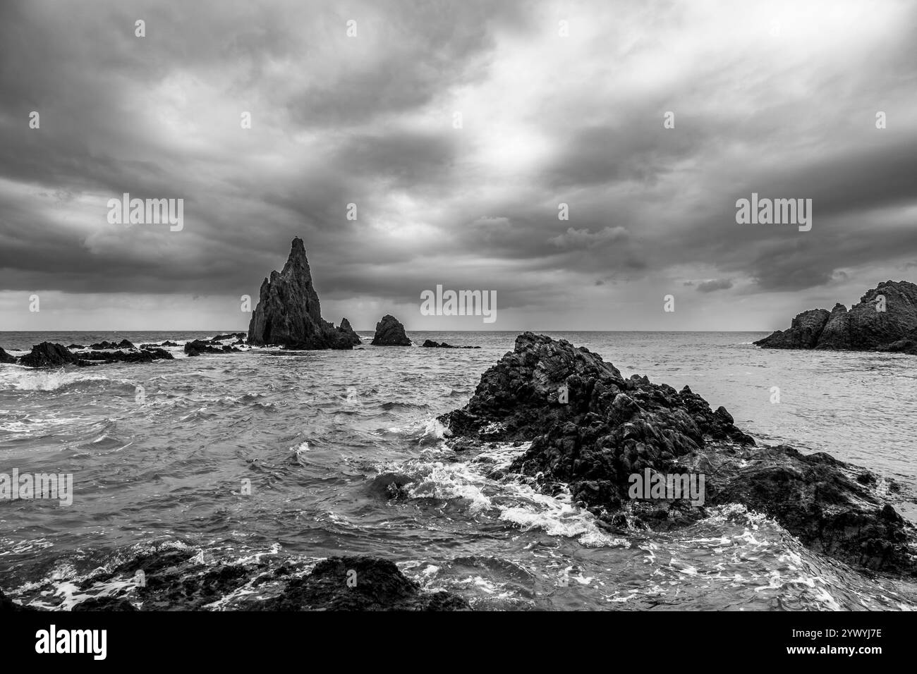 Vista in bianco e nero delle rocce marine di Las Sirenas (Cabo de Gata, Spagna) in una mattinata tempestosa Foto Stock