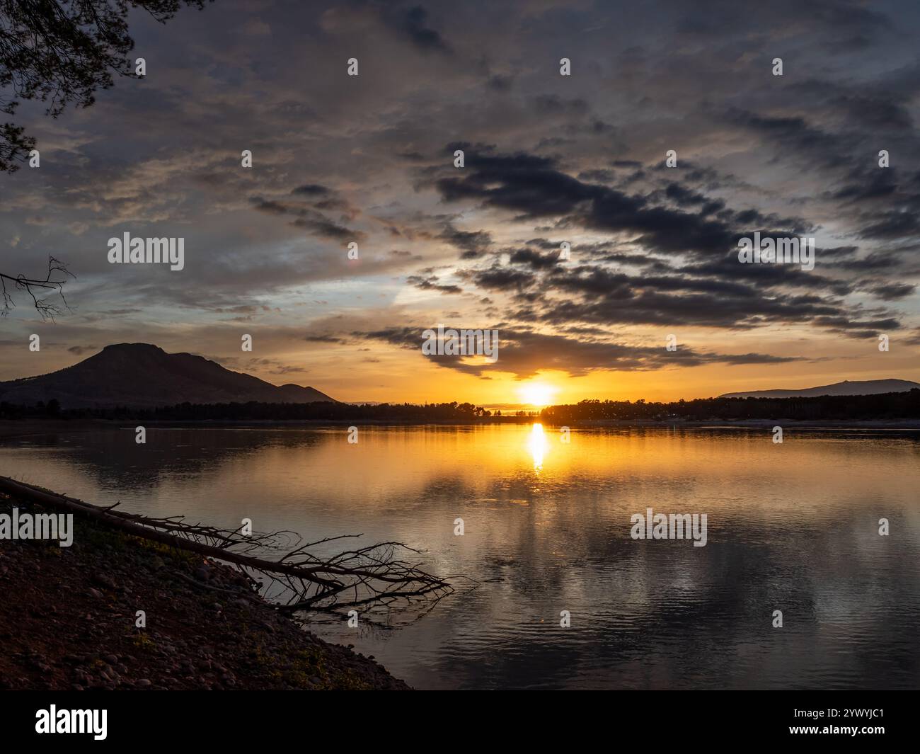 Paesaggio di un lago con il riflesso delle montagne e delle nuvole al tramonto autunnale a Granada (Spagna) Foto Stock