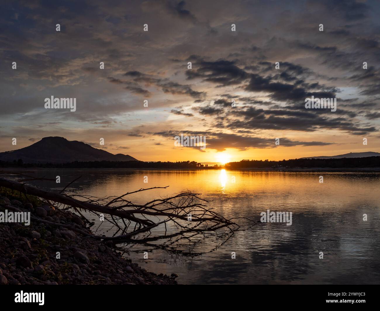 Paesaggio di un lago con il riflesso delle montagne e delle nuvole al tramonto autunnale a Granada (Spagna) Foto Stock