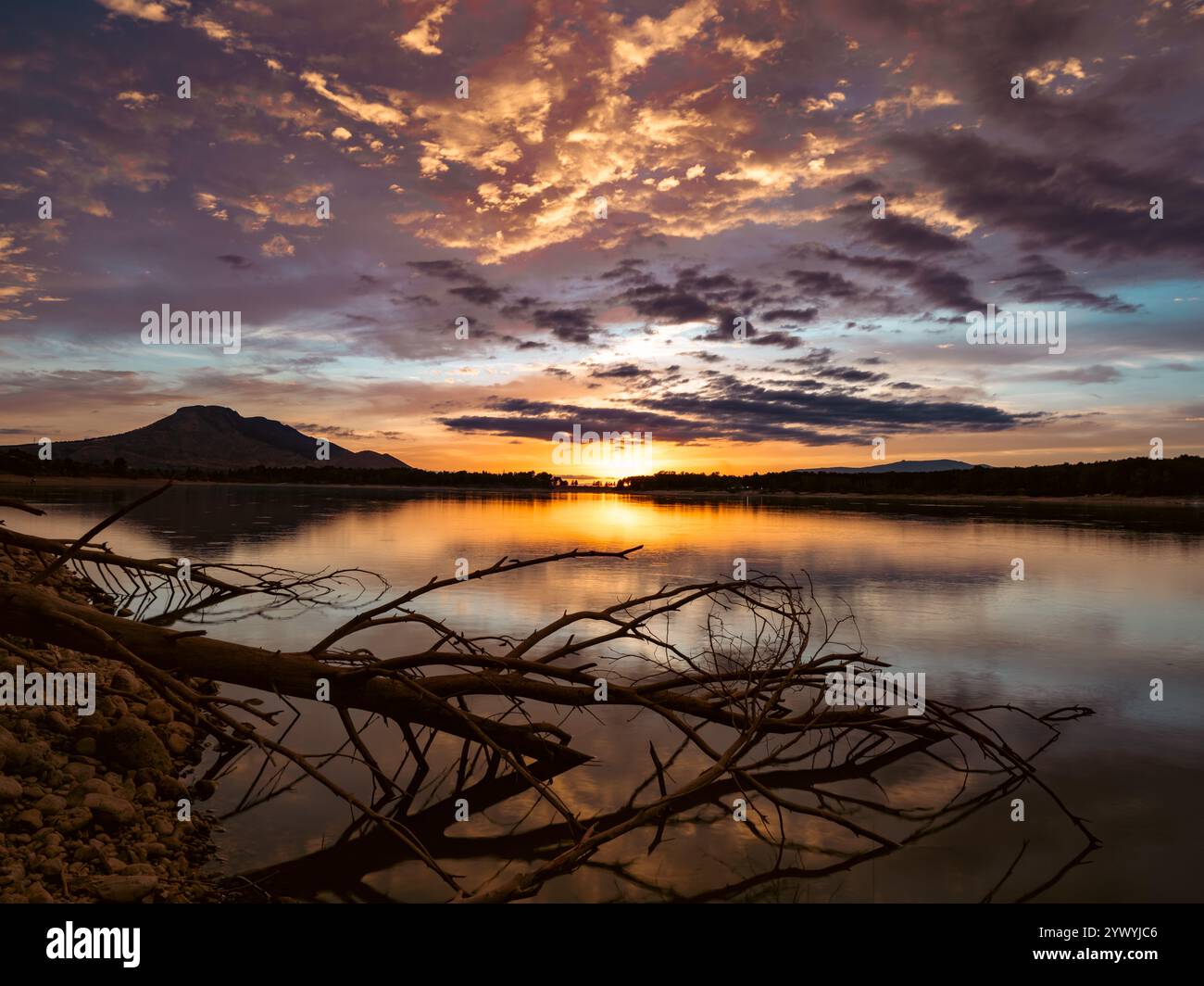 Paesaggio di un lago con il riflesso delle montagne e delle nuvole al tramonto autunnale a Granada (Spagna) Foto Stock