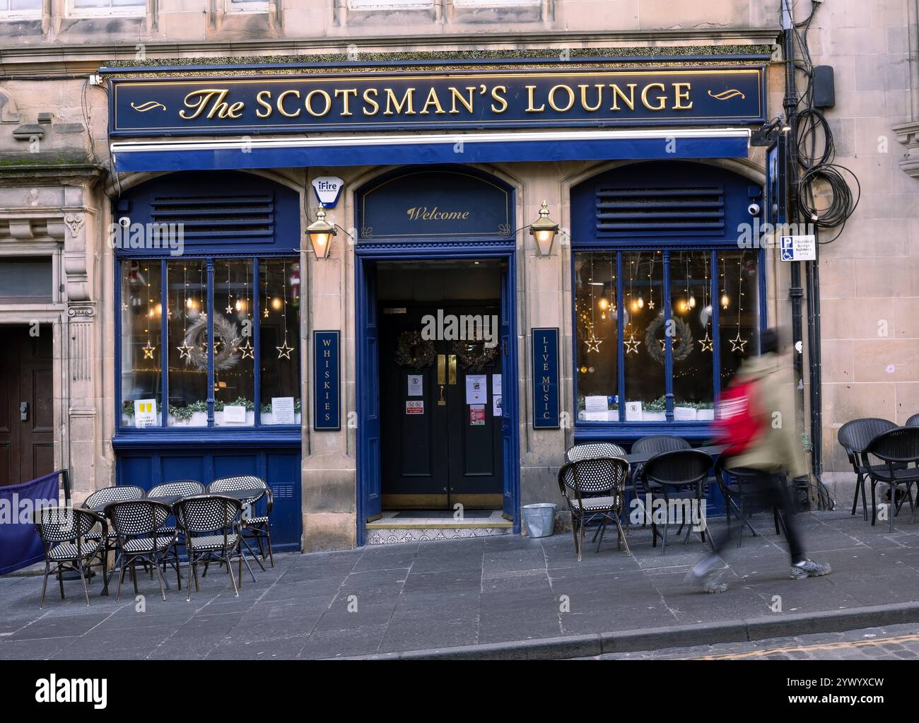 Lady che passa per la Scotsman Lounge in Cockburn Street, Edimburgo, Scozia, Regno Unito Foto Stock