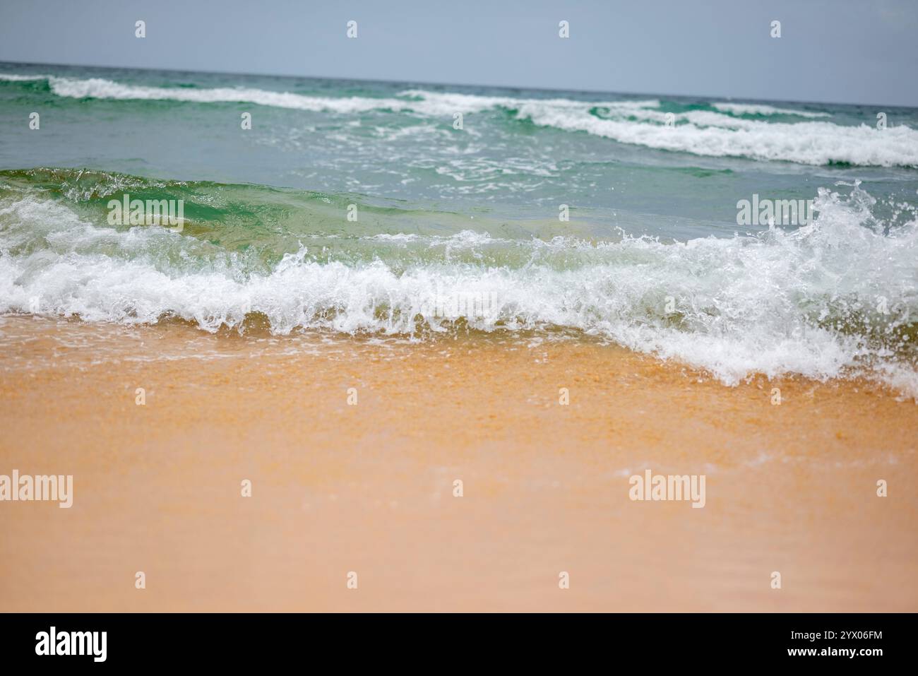 Gentle Waves Lapping su Sandy Beach Foto Stock