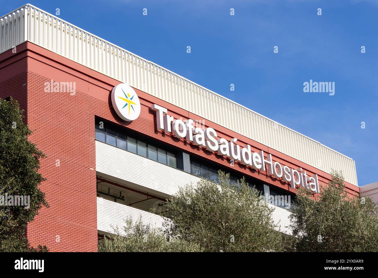 Moderno edificio ospedaliero esterno con logo e cartellonistica in una giornata di sole chiaro Foto Stock