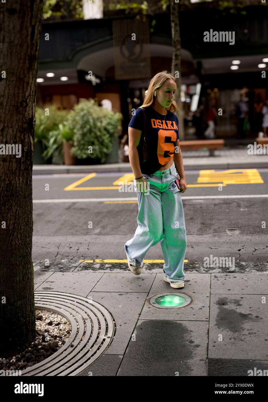 Foto di strada candida scattata in Queen's Street di Auckland. La luce verde alimentata dalle luci posizionate sul marciapiede. Foto Stock