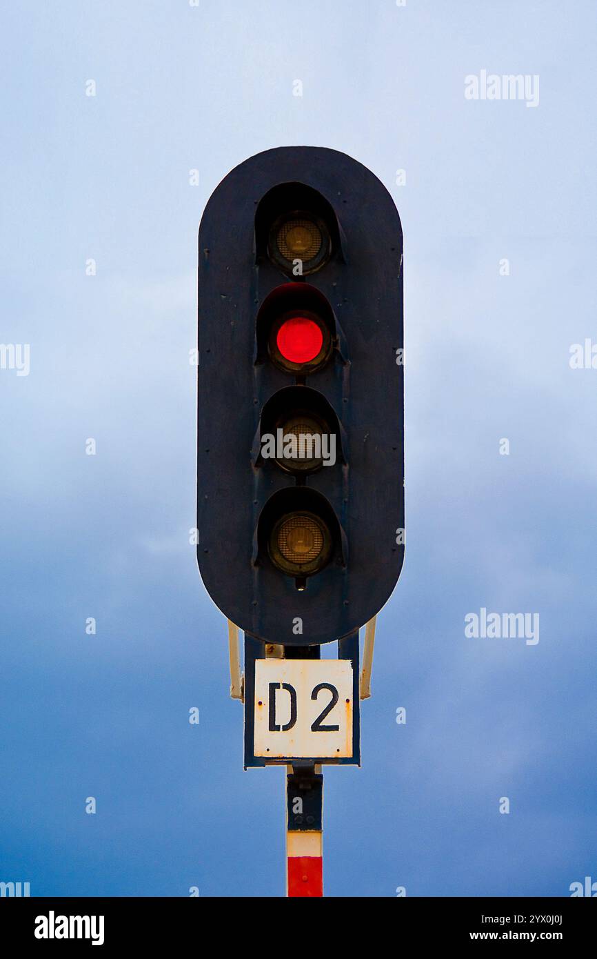Semaforo, semaforo sulla stazione ferroviaria girato contro il cielo blu nuvoloso. Foto Stock