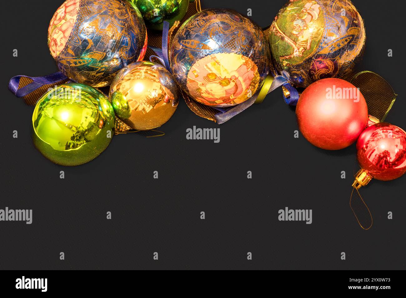 Decorazioni natalizie con palline di vetro scintillanti su sfondo grigio scuro e molto spazio per il testo Foto Stock