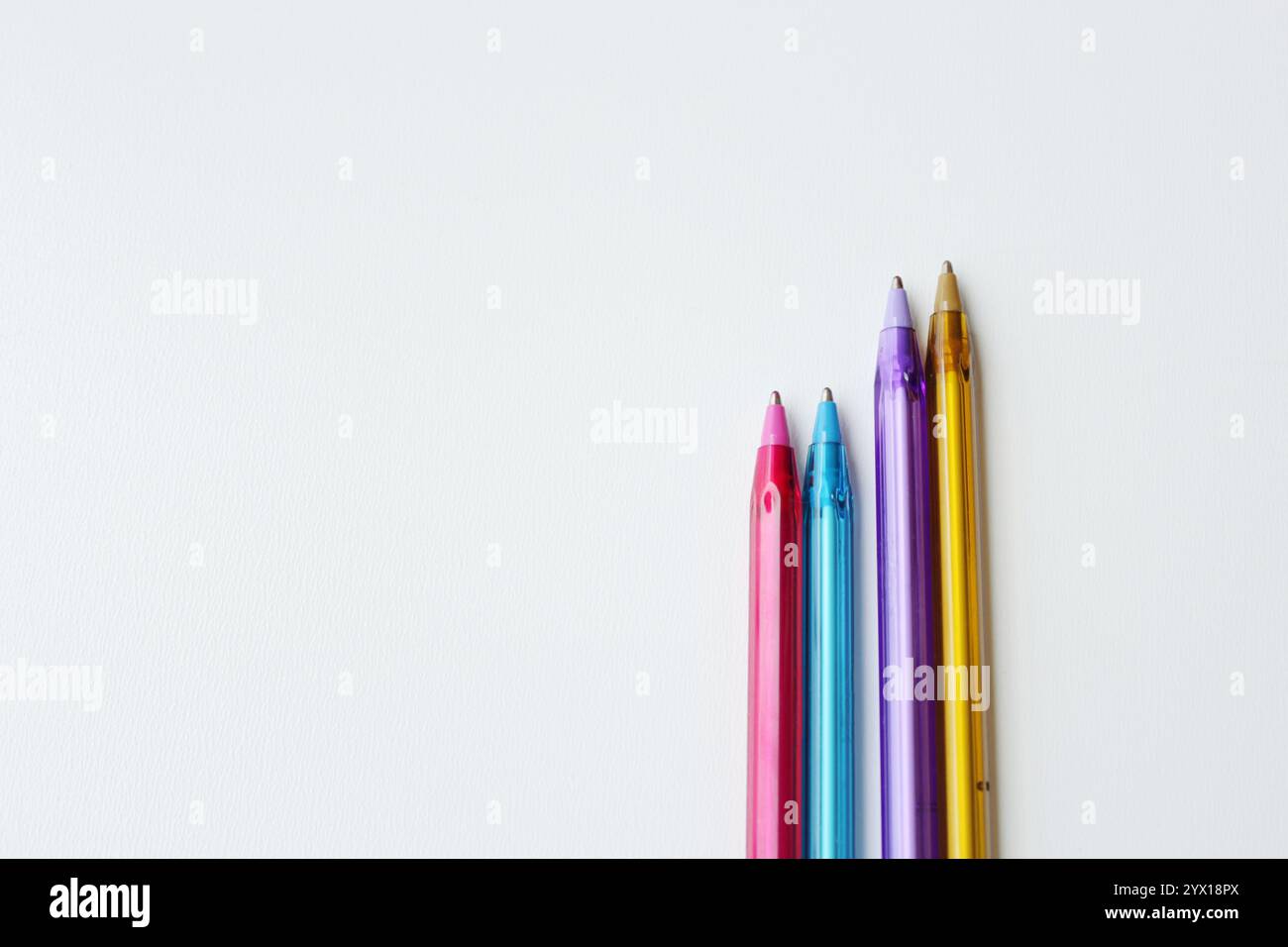 Quattro penne a sfera su sfondo bianco orizzontale con spazio di copia. Cancelleria creativa, forniture scolastiche, lezione di disegno, concetto di creazione di contenuti. Foto Stock