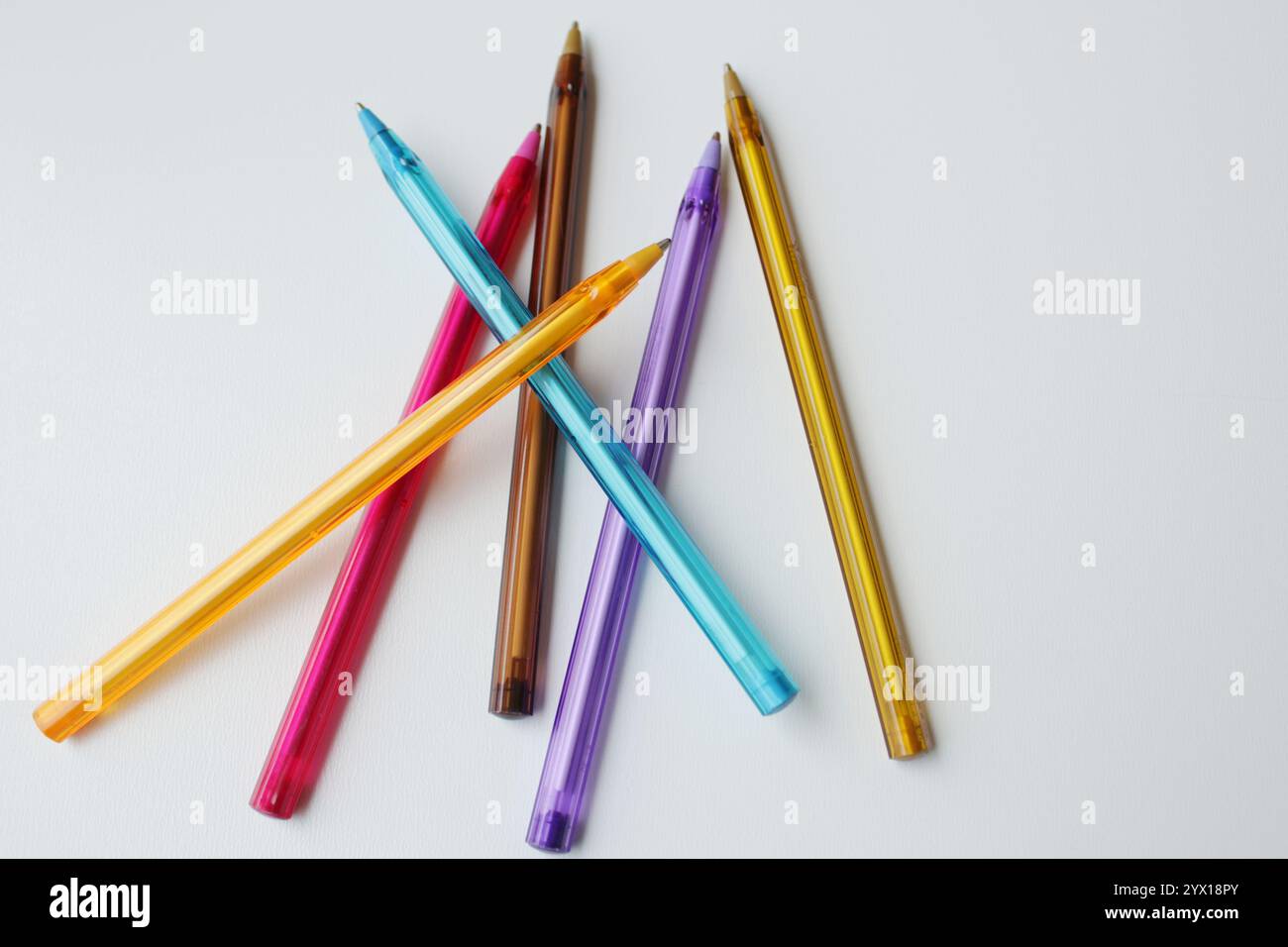 Gruppo di penne colorate sparse su sfondo bianco. Cancelleria a colori, forniture scolastiche, lezione d'arte, lezione di disegno, concetto di creatività. Foto Stock