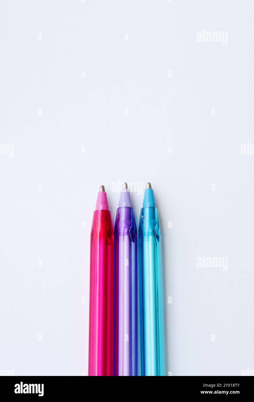 Penna a sfera a tre punte di colore freddo su sfondo bianco verticale con spazio di copia. Cancelleria creativa, forniture scolastiche, lezione di disegno, creazione di contenuti Foto Stock