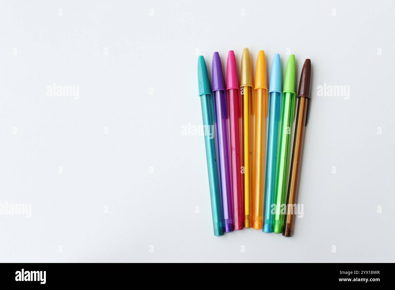 Penne colorate disposte affiancate su sfondo bianco. Sfumatura di colore con penna a sfera. Cancelleria, forniture scolastiche, concetto di creatività. Foto Stock