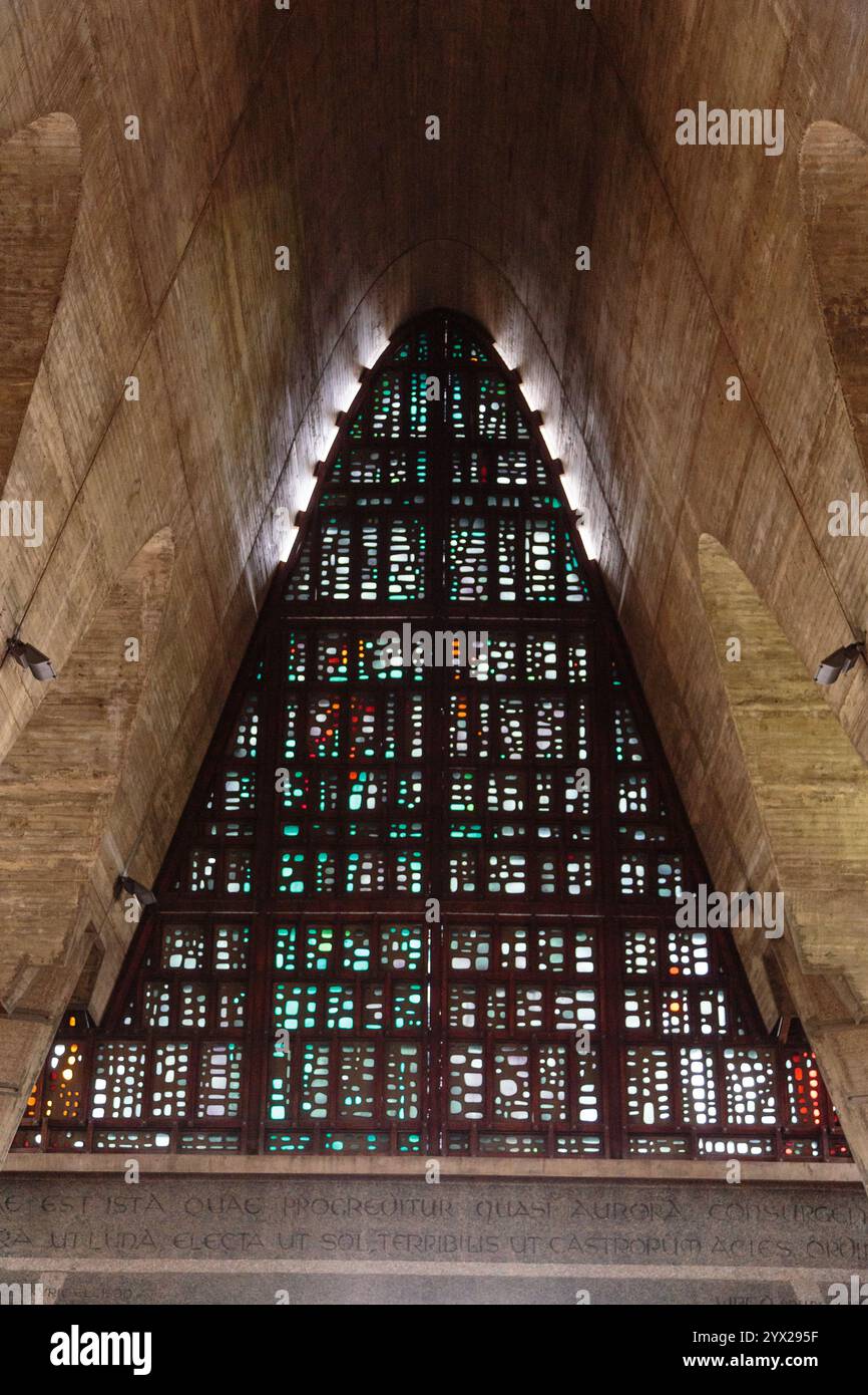 Una vetrata colorata in una chiesa a forma di triangolo. La finestra e' piena di molti piccoli pezzi di vetro, creando una bella e intricata des Foto Stock