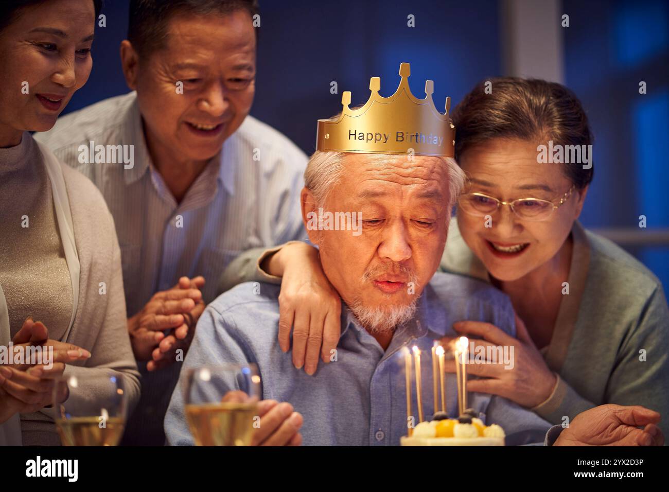 buon vecchio asiatico che festeggia il compleanno con gli amici anziani a casa di notte Foto Stock