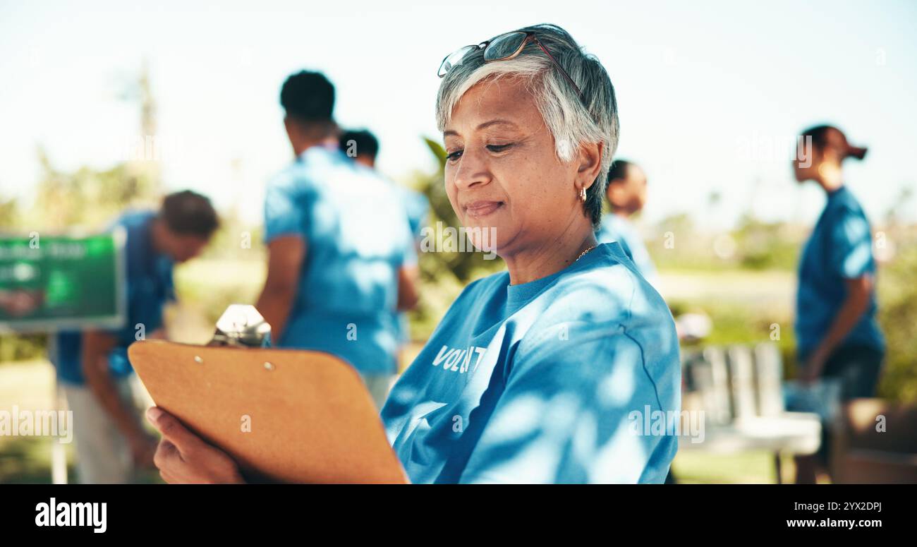 Associazione benefica, lista di controllo e appunti con donna volontaria all'aperto nel parco per un'iniziativa alimentare comunitaria o una donazione. Attivismo, documenti e manifesto con Foto Stock