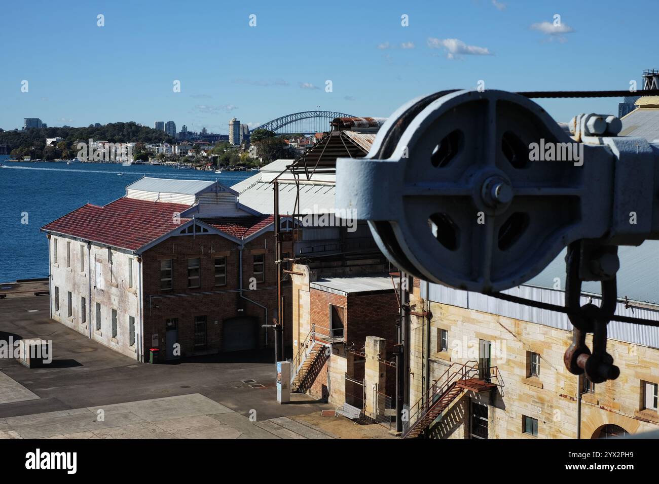 Carrucole ed edifici industriali sull'isola di Cockatoo con vista sul Sydney Harbour Bridge, Sydney, Australia Foto Stock