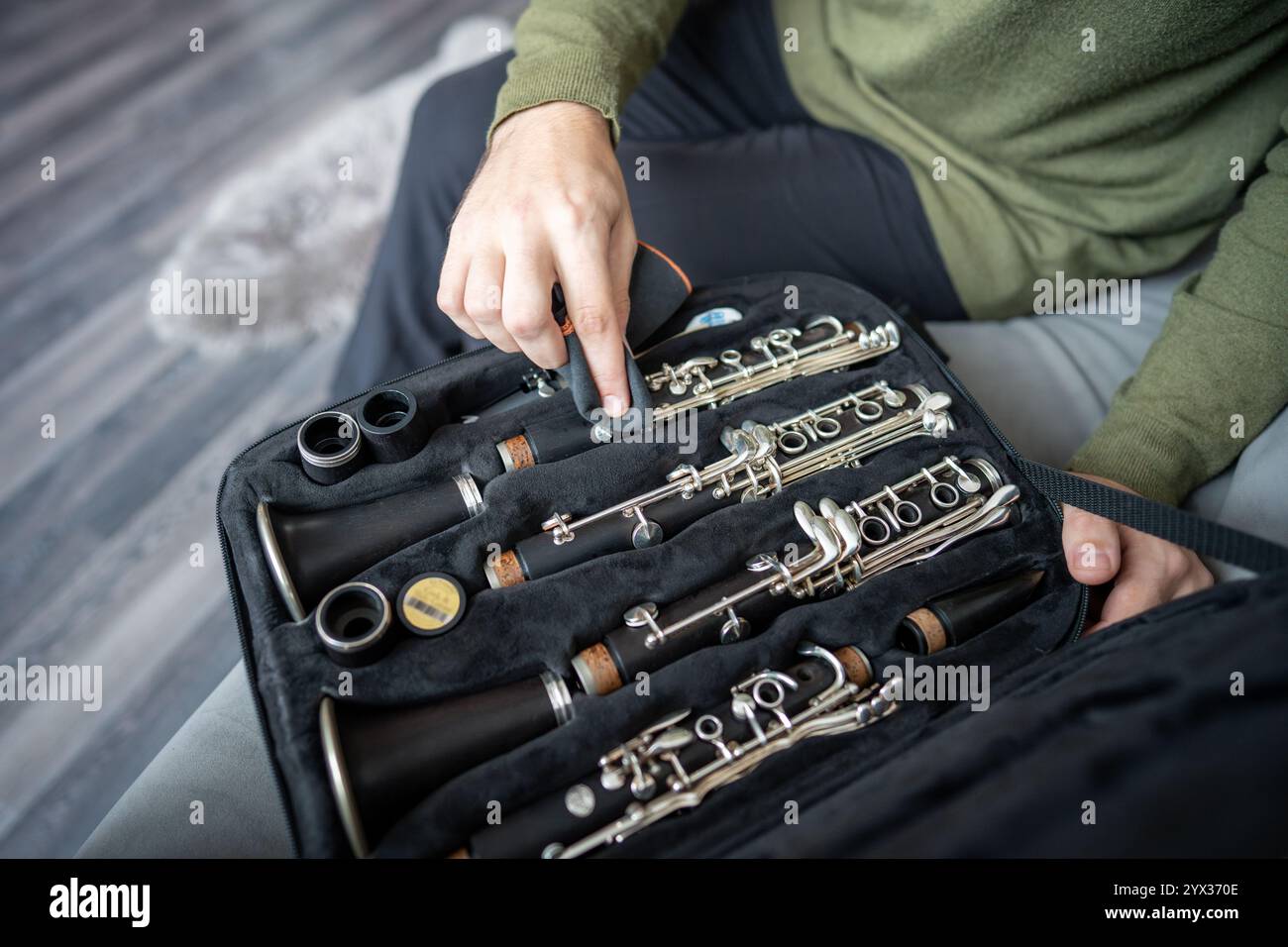 L'uomo posiziona con cura il clarinetto smontato nella custodia, pulisce le parti per rimuovere polvere e impronte digitali. Foto Stock