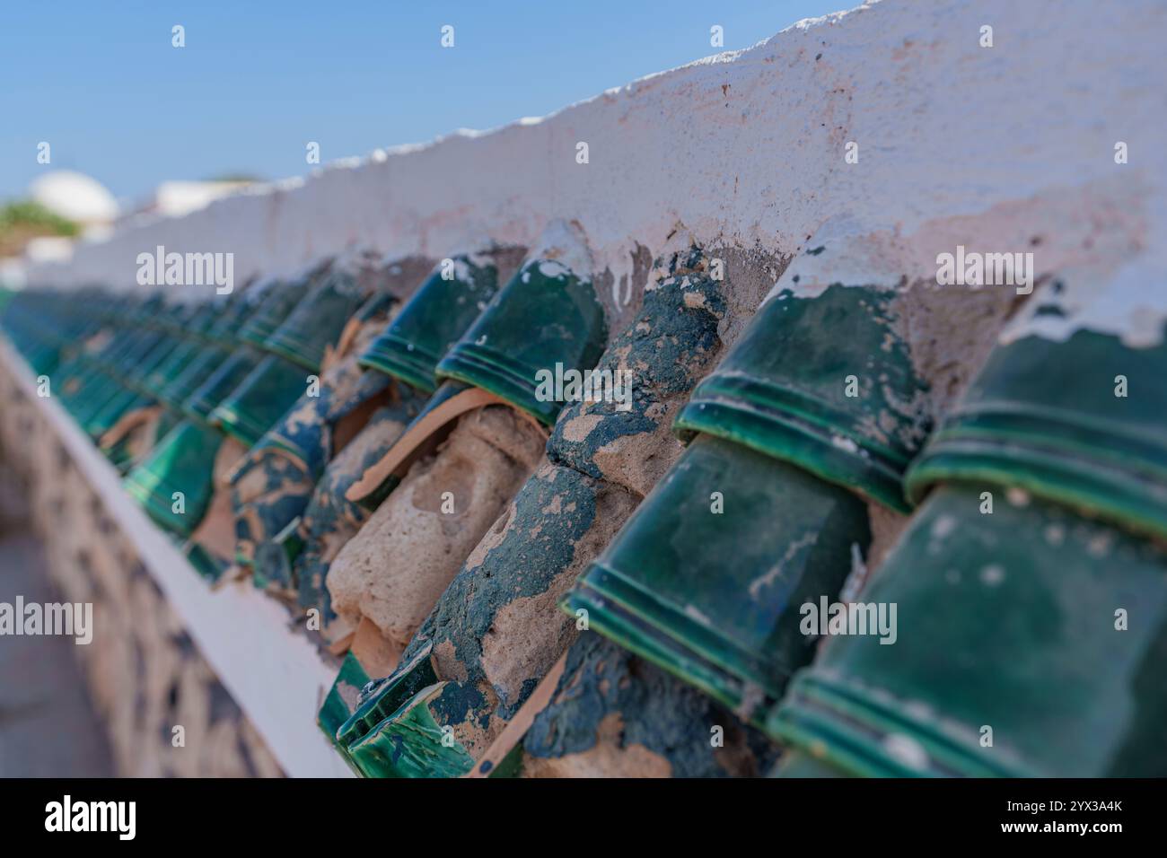 Vista della parte superiore della recinzione coperta da bellissime piastrelle verdi del tetto Foto Stock