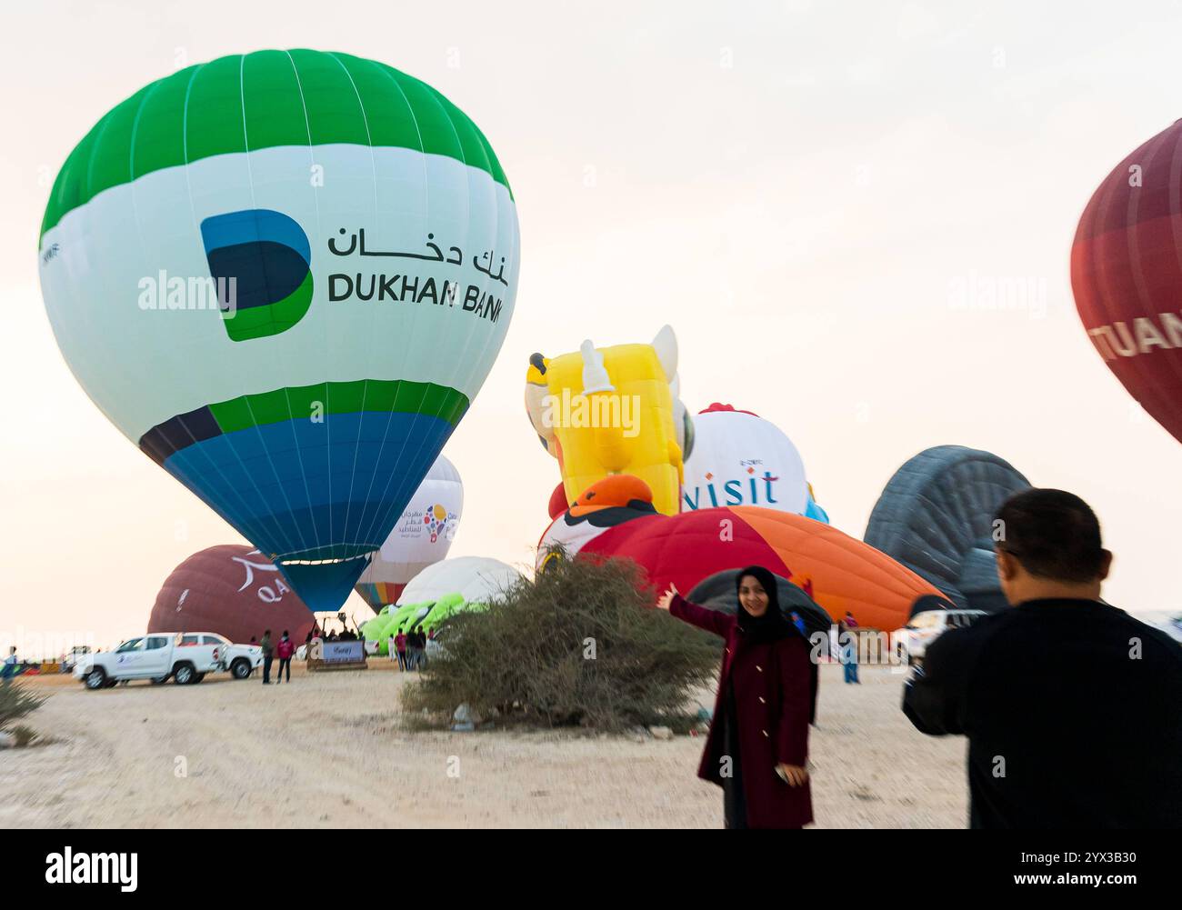 QATAR BALLOON FESTIVAL 2024 persone scattano foto di mongolfiere che decollano all'alba durante il Qatar Balloon Festival 2024 a Doha, Qatar, il 13 dicembre 2024. La quinta edizione del Qatar Balloon Festival si è tenuta qui dal 12 al 22 dicembre e più di 50 partecipanti partecipano al Festival DOHA Qatar Copyright: XNOUSHADx Foto Stock