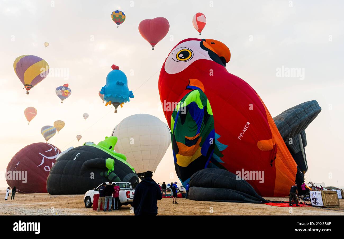 QATAR BALLOON FESTIVAL 2024 persone guardano le mongolfiere decollare durante il Qatar Balloon Festival 2024 a Doha, Qatar, il 13 dicembre 2024. La quinta edizione del Qatar Balloon Festival si è tenuta qui dal 12 al 22 dicembre e più di 50 partecipanti partecipano al Festival DOHA Qatar Copyright: XNOUSHADx Foto Stock