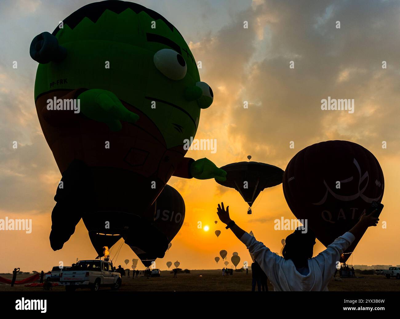 QATAR BALLOON FESTIVAL 2024 persone guardano le mongolfiere decollare all'alba durante il Qatar Balloon Festival 2024 a Doha, Qatar, il 13 dicembre 2024. La quinta edizione del Qatar Balloon Festival si è tenuta qui dal 12 al 22 dicembre e più di 50 partecipanti partecipano al Festival DOHA Qatar Copyright: XNOUSHADx Foto Stock