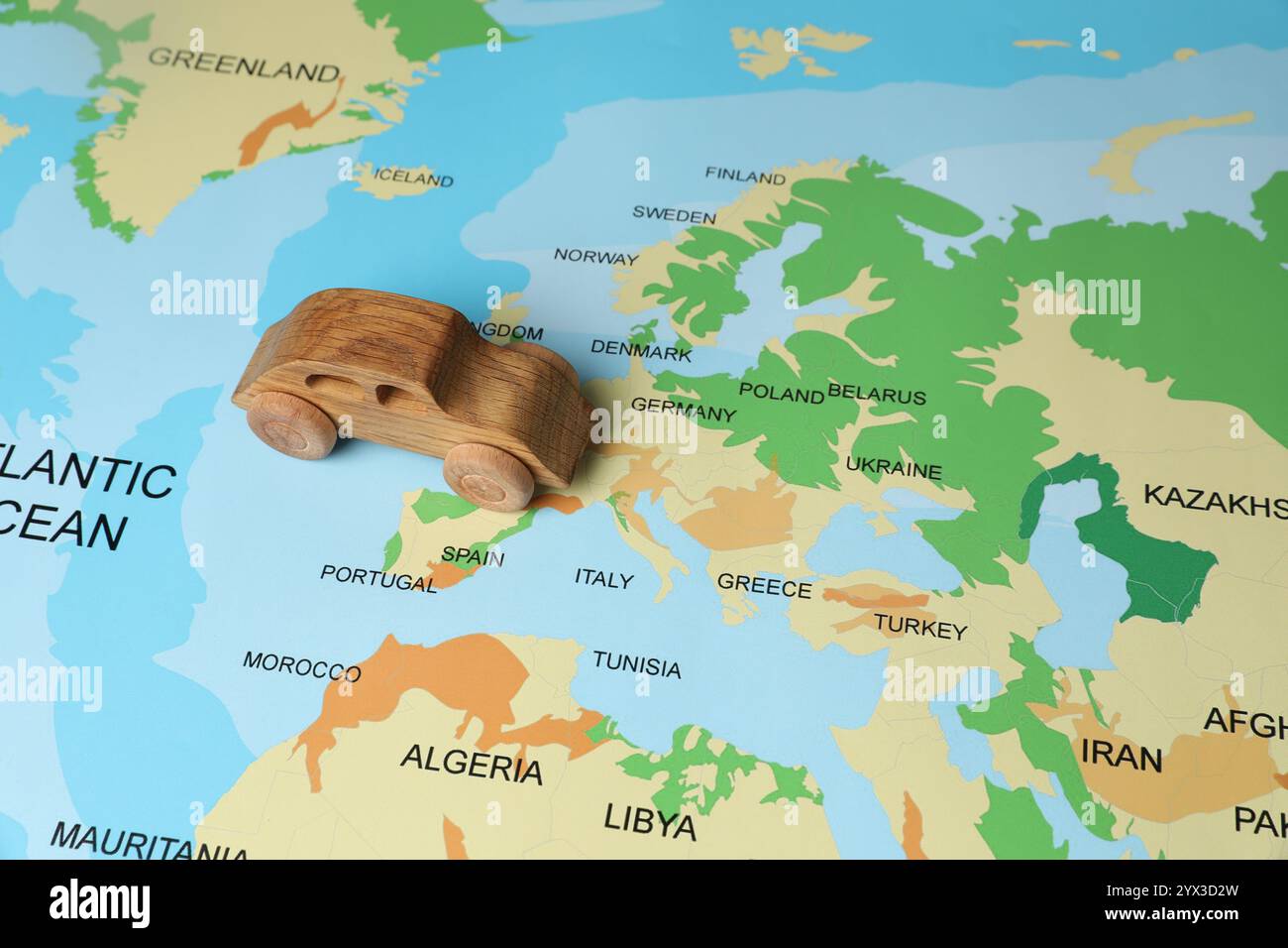 Macchinetta giocattolo in legno sulla mappa del mondo. Viaggio in auto Foto Stock