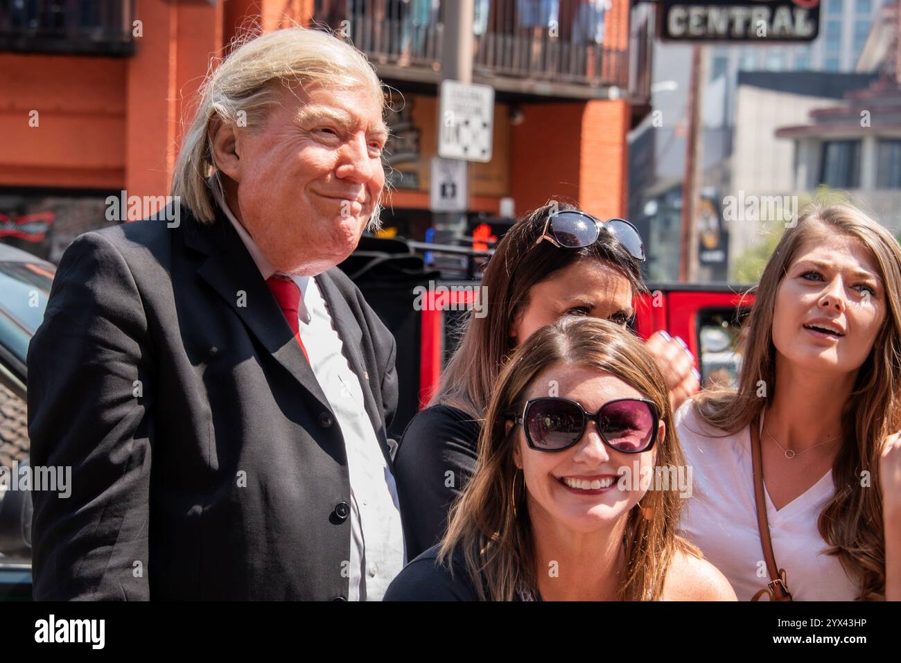 Il presidente Trump è visto salutare calorosamente un gruppo di turisti entusiasti a Nashville. L'iconico skyline della città funge da sfondo, mentre il turista Foto Stock