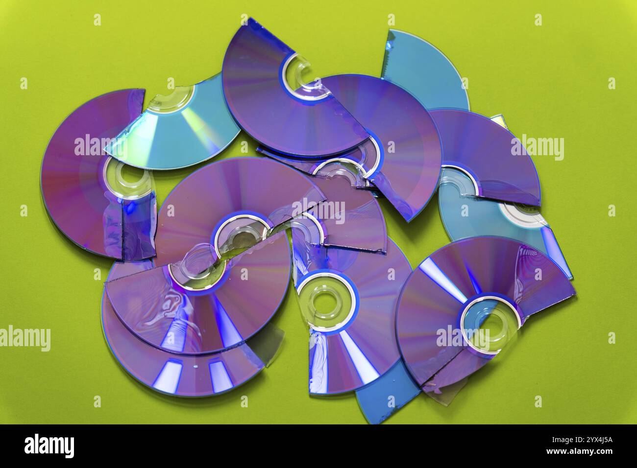 Vista dall'alto di CD e DVD tagliati su sfondo verde Foto Stock