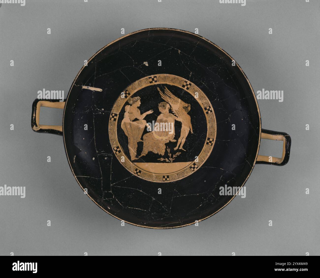 Attico Red-Figure Kylix, circa 410 a.C. Bicchiere di vino con Demonassa e Peitho. Ulteriori informazioni: Peitho, la dea della persuasione, si rivolge a una donna di nome Demonassa, che siede in un paesaggio roccioso che sembra piuttosto sgrettato. A destra, un piccolo Eros alato, il dio dell'amore, mette la mano sulla spalla di Demonassa, il che rende chiaro il tema del messaggio della persuasione. Nella mitologia greca, Afrodite, la dea dell'amore, diede Demonassa a Fone, un ferryman sull'isola di Lesbo, in cambio di un servizio che aveva fatto per la dea. Questo bicchiere fornisce un esempio insolitamente buono della divisione o. Foto Stock