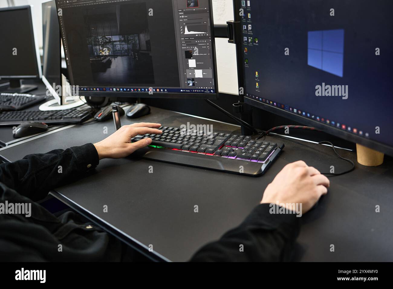 Editing di foto su computer da parte di un designer grafico utilizzando un software per il lavoro creativo, mostrato con configurazione a doppio monitor, concetto di arte digitale Foto Stock