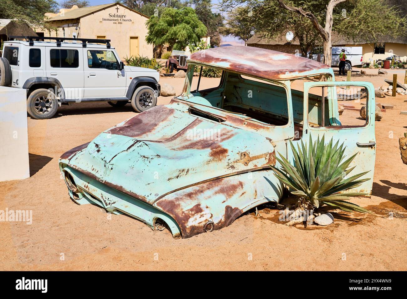 Rusty vecchia auto metà sommersa nella sabbia di un deserto, Car Wrelks di Solitare, Namibia Foto Stock