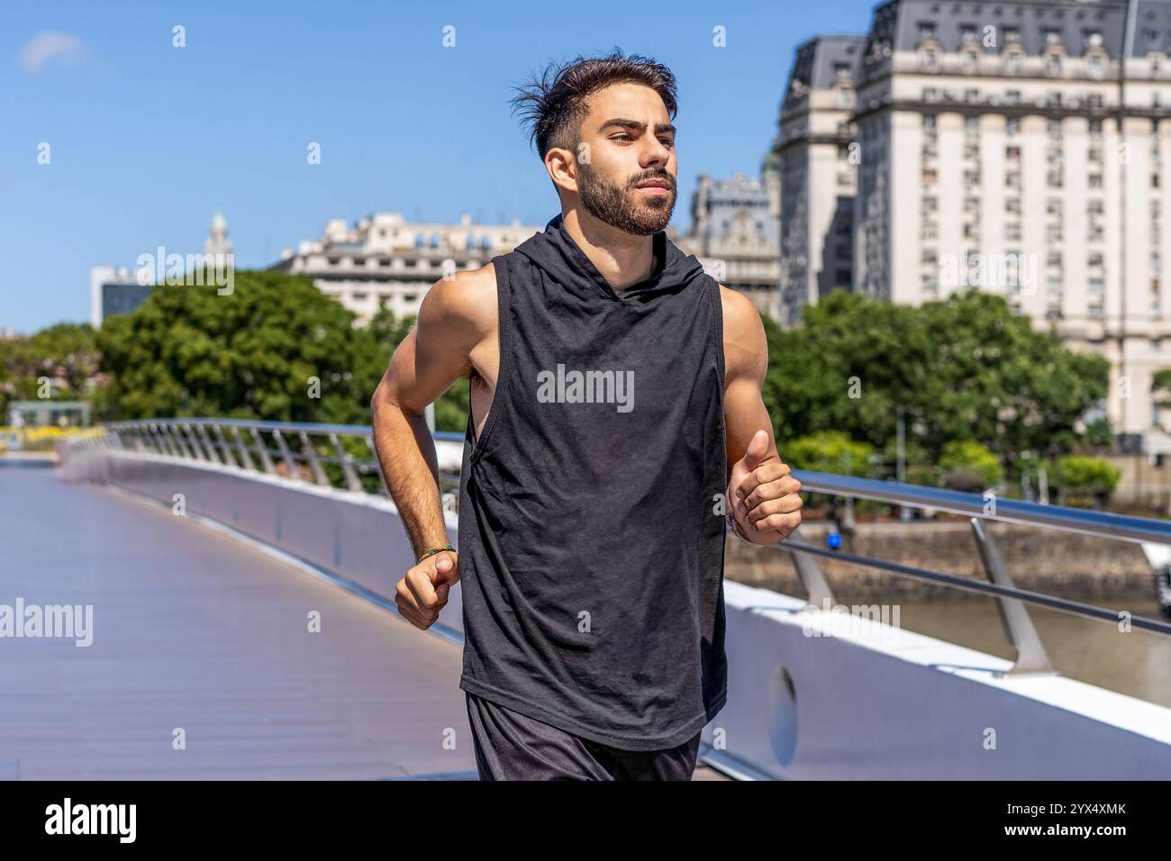 Giovane che corre su un ponte con il panorama del canale. Foto Stock