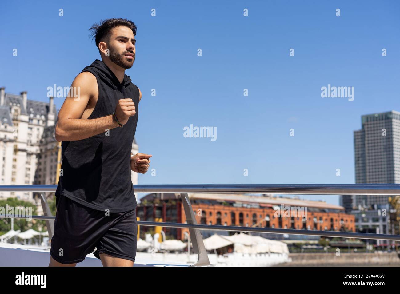 Tenetevi in forma immersi in una routine di jogging lungo un ponte. Foto Stock