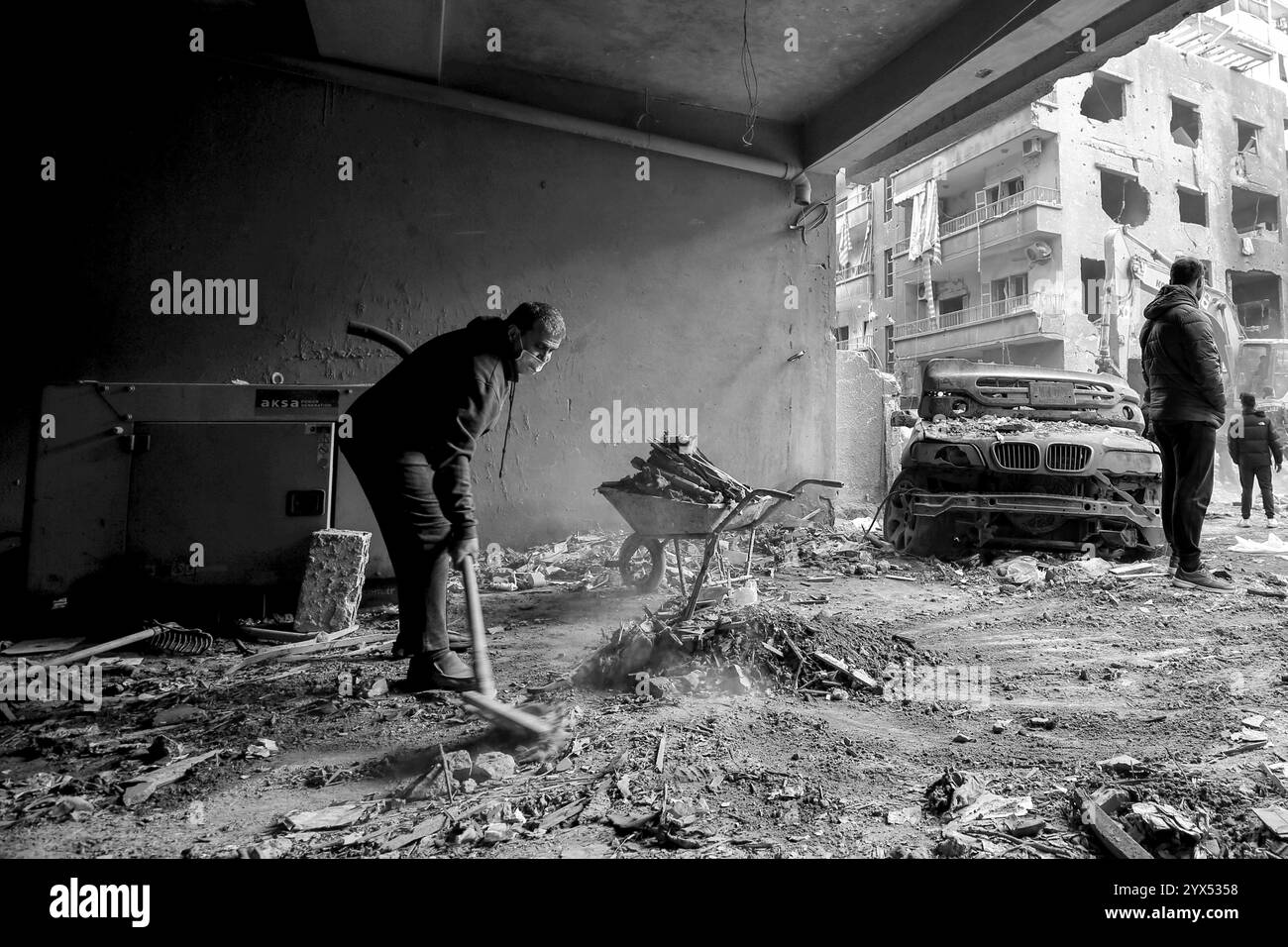 Beirut, Beirut, Libano. 13 dicembre 2024. Un libanese pulisce i detriti dall'ingresso di un edificio nel devastato quartiere di basta che è stato colpito da incursioni aeree durante i due mesi di guerra totale tra Israele e militanti di Hezbollah. I residenti della zona alzarono la voce chiedendo al governo un risarcimento per decine di edifici devastati e di trovare ripari per le famiglie che hanno perso le loro case. (Credit Image: © Marwan Naamani/ZUMA Press Wire) SOLO PER USO EDITORIALE! Non per USO commerciale! Foto Stock