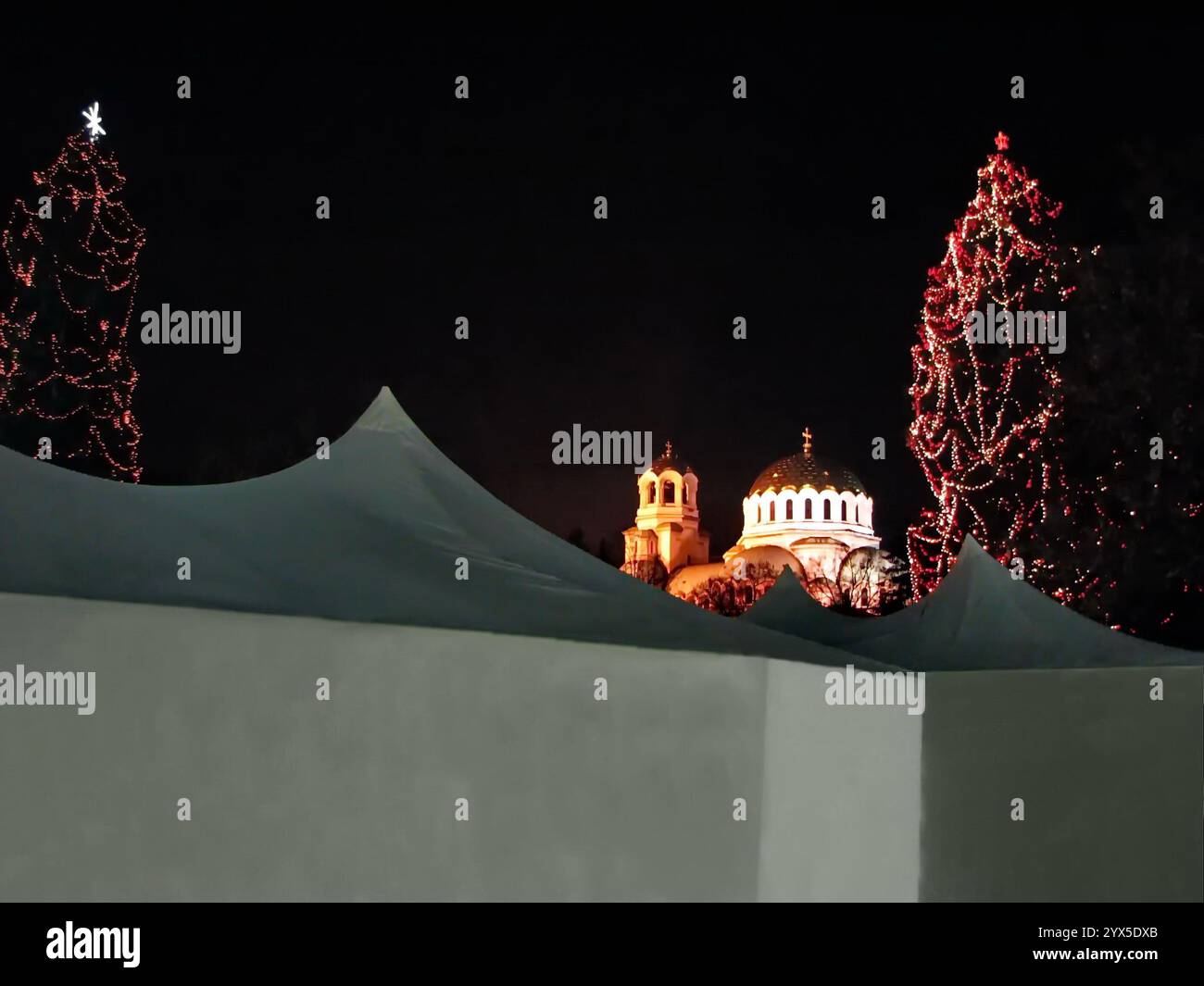 Vista degli alberi di Natale decorati a festa e delle tende da regalo nella piazza di fronte alla cattedrale Alexander Nevsky, Sofia, Bulgaria Foto Stock