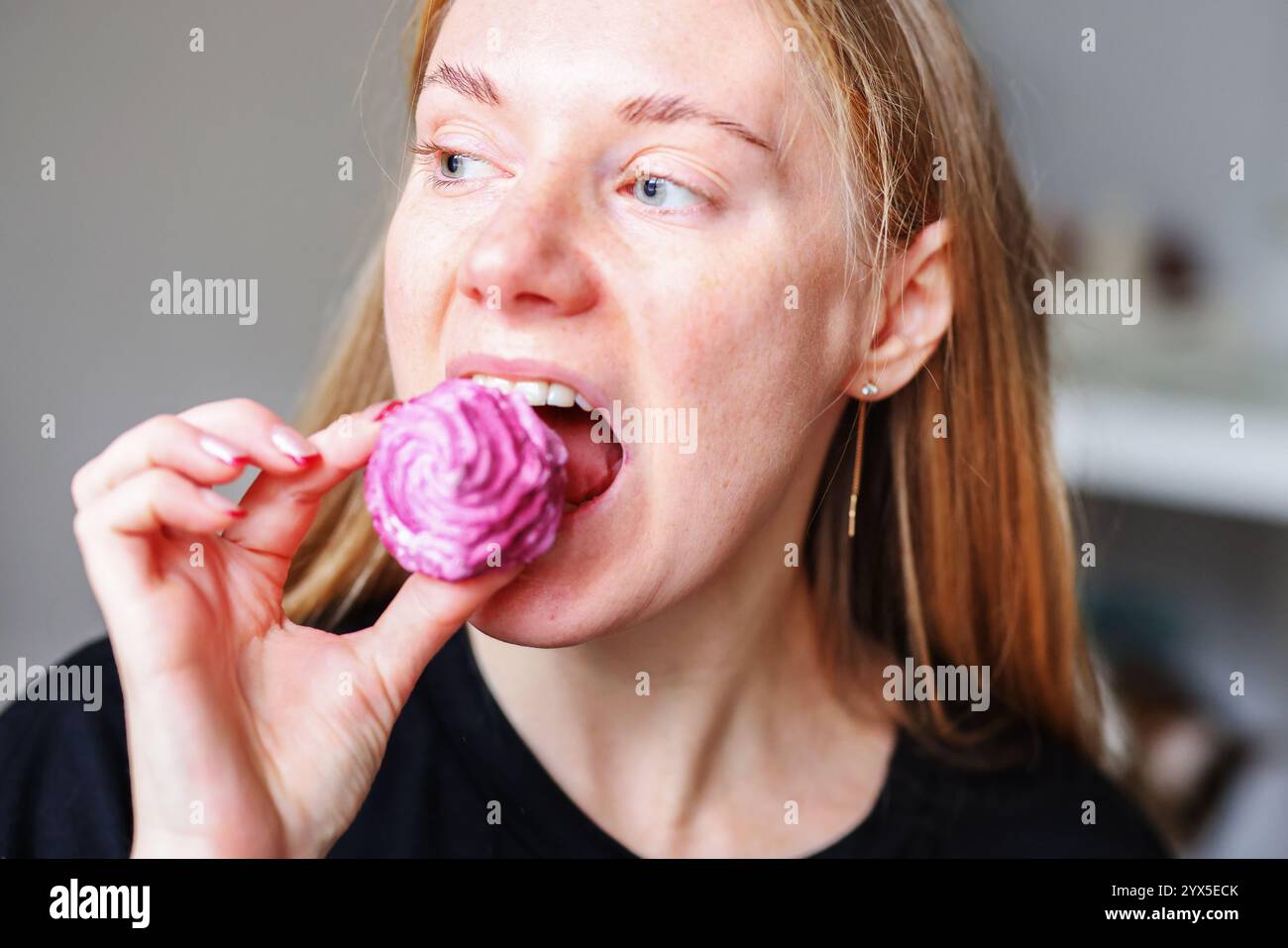 la ragazza mangia zephyr fatto in casa. Marshmallow fatti in casa. Una donna mette uno zephyr pronto all'uso Foto Stock