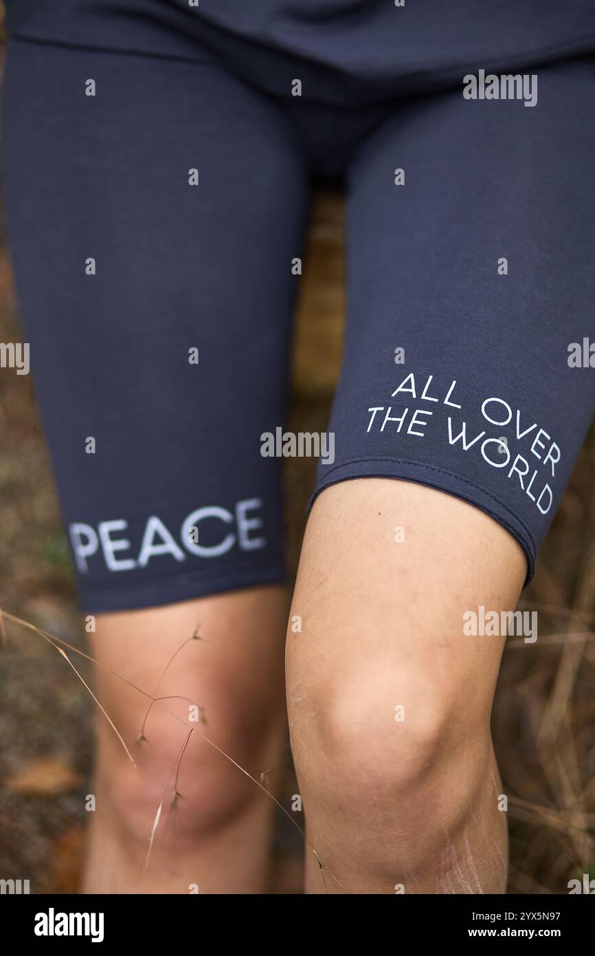 Individuale con pantaloncini Peace Message in un ambiente all'aperto circondato dal concetto di riflessione sulla natura Foto Stock