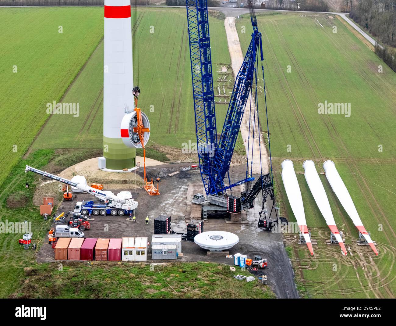 Installazione di una turbina eolica, tipo Enercon e-138. Lo statore, parte del generatore, viene tirato alla navicella da una grande gru cingolata, Ahlen wind f Foto Stock