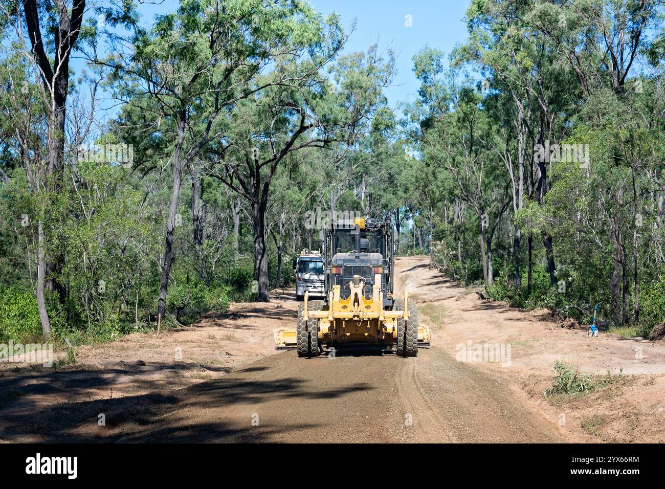 Macchine per livellamento su strada sterrata rurale, foresta australiana di eucalipti gommosi, riparazione di lavori stradali, distanza di trasporto pubblico isolata Foto Stock
