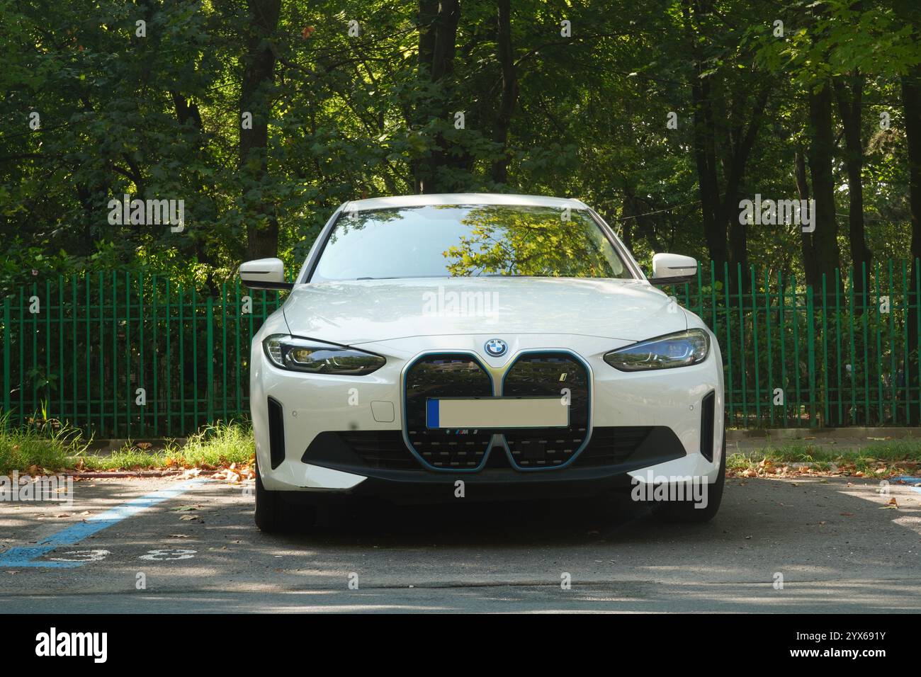 Bucarest, Romania - 22 luglio 2024: BMW i4 edrive40 auto elettrica bianca parcheggiata nel parcheggio di fronte al recinto del parcheggio Foto Stock