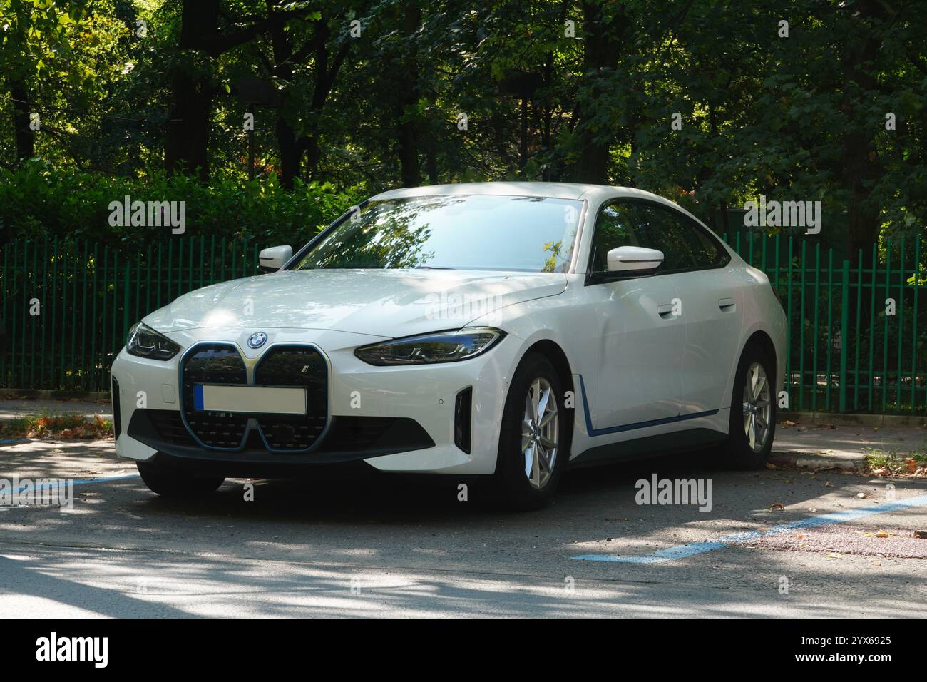 Bucarest, Romania - 22 luglio 2024: Vista frontale della BMW i4 edrive40 auto elettrica bianca parcheggiata nel parcheggio di fronte al recinto del parcheggio Foto Stock