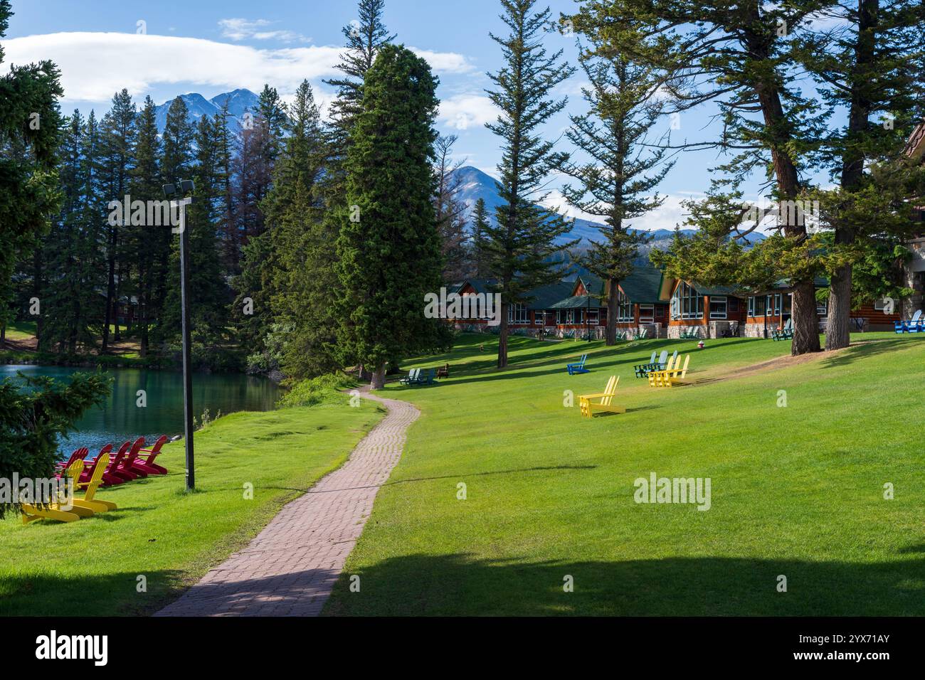 Alberta, Canada - 8 giugno 2021: Cabine Fairmont Jasper Park Lodge Resort. Sedie Adirondack sul lago Beauvert, Lac Beauvert Trail. Foto Stock